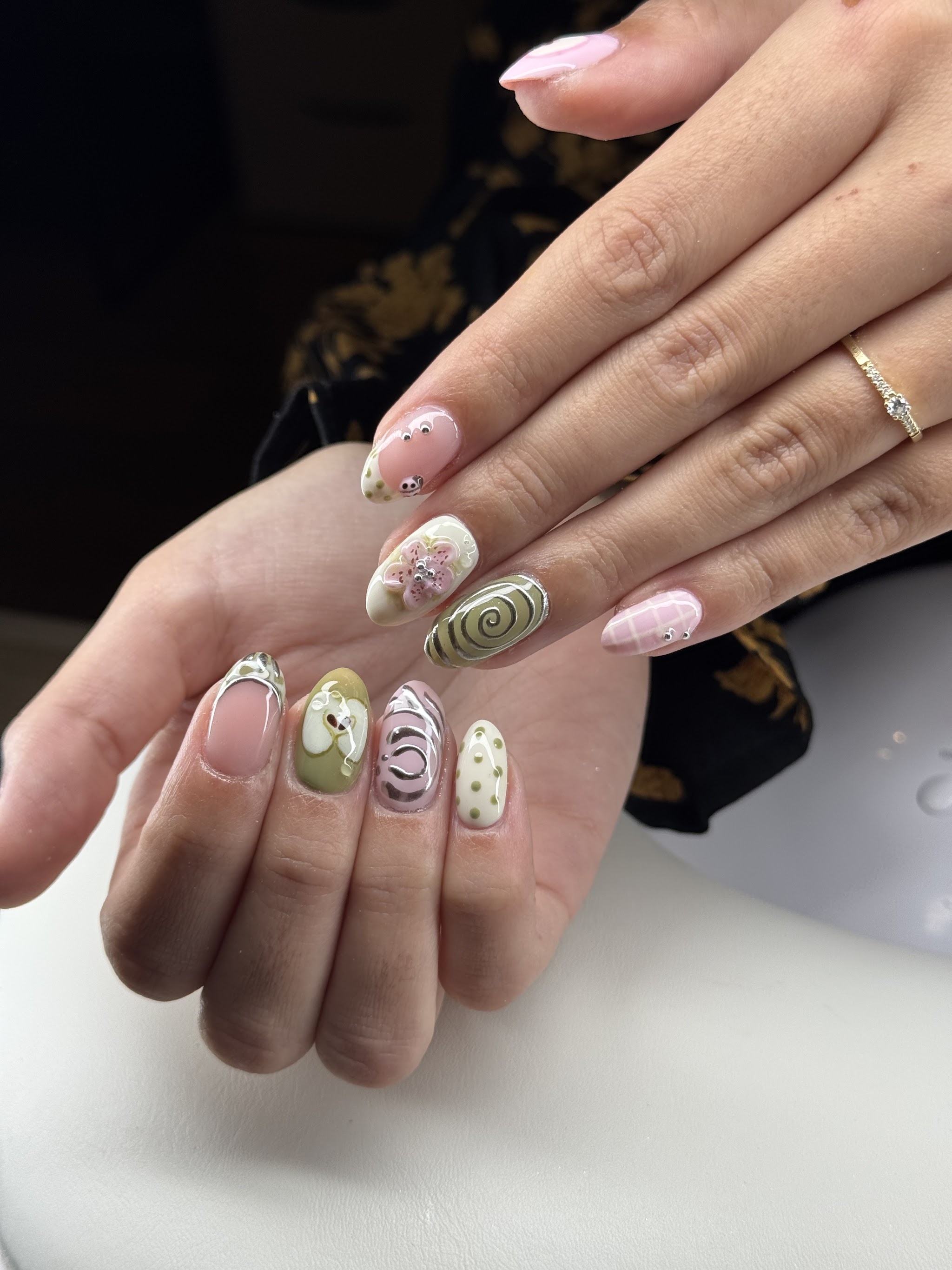 Amandelvormige nagels in pastel en olijfgroen met swirls en stipjes
