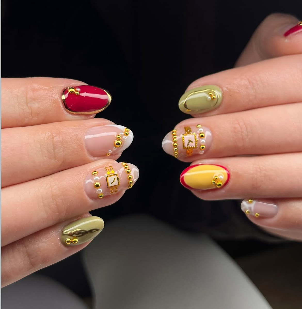Nagels in rood, olijfgroen en geel met gouden 3D-pareltjes